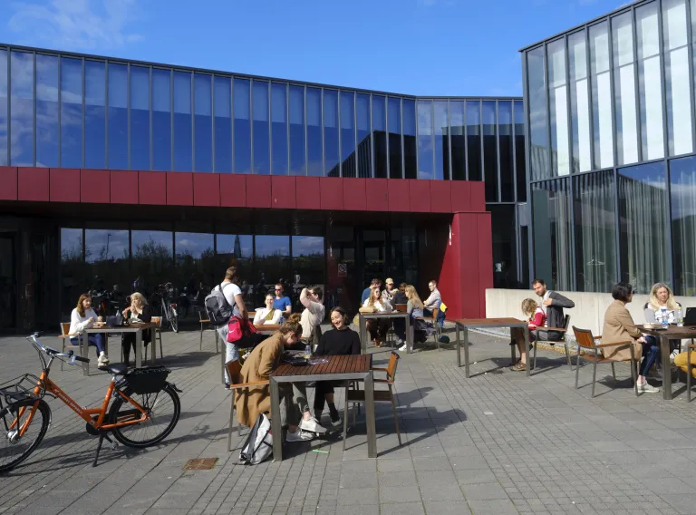 People sitting in the sun outside of University centre in the summertime
