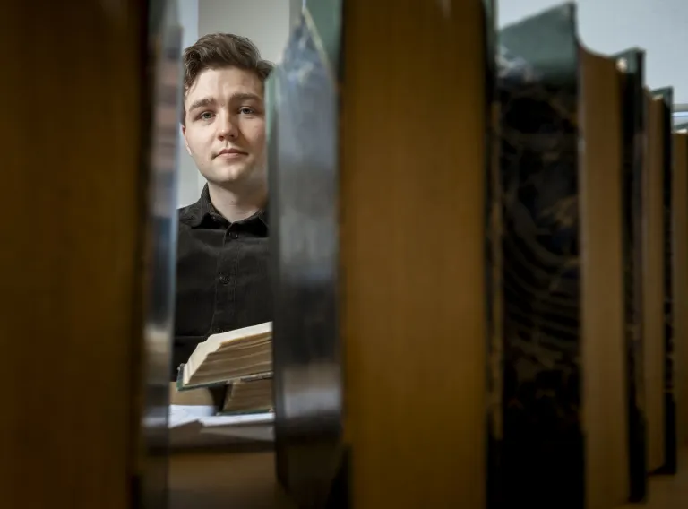 Student sitting behind books
