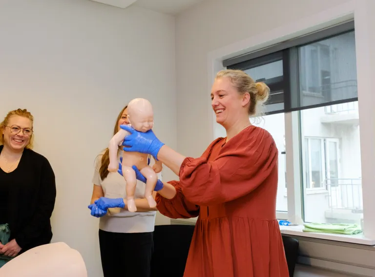 Practicing on holding a baby after birth. Baby a medical doll. 