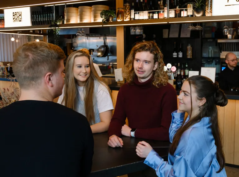 Four students talking to each other.
