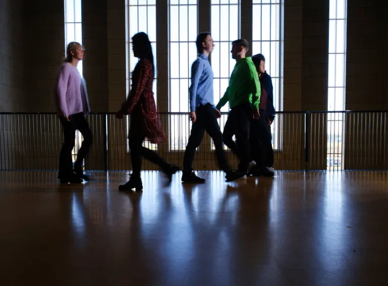  A silhouette of students walking in the opposite direction from each other. 