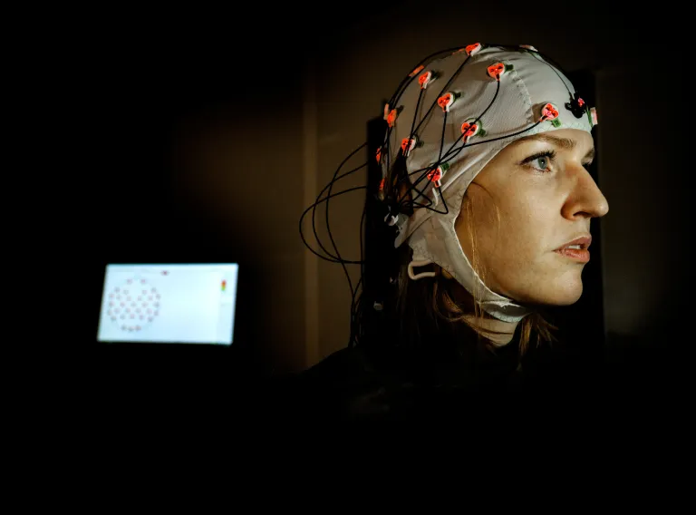 Woman's head connected to measuring electrodes.