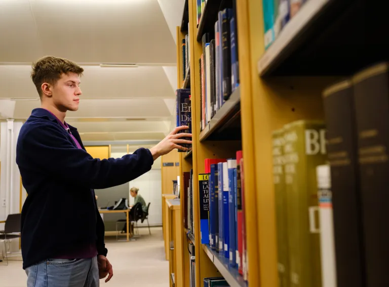 Student looking at books at the library