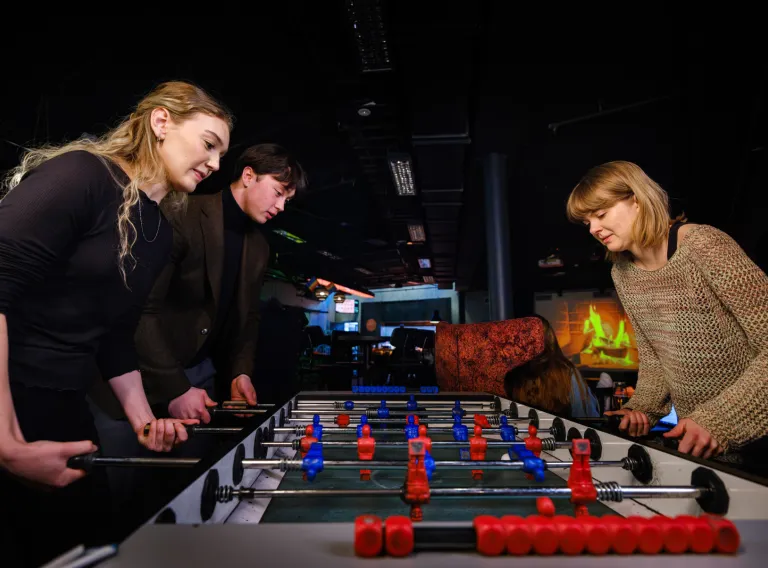 Students playing foosball in the student cellar