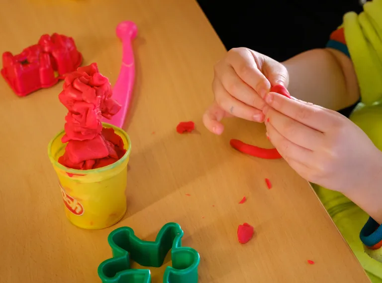 Preschool pupil playing with clay