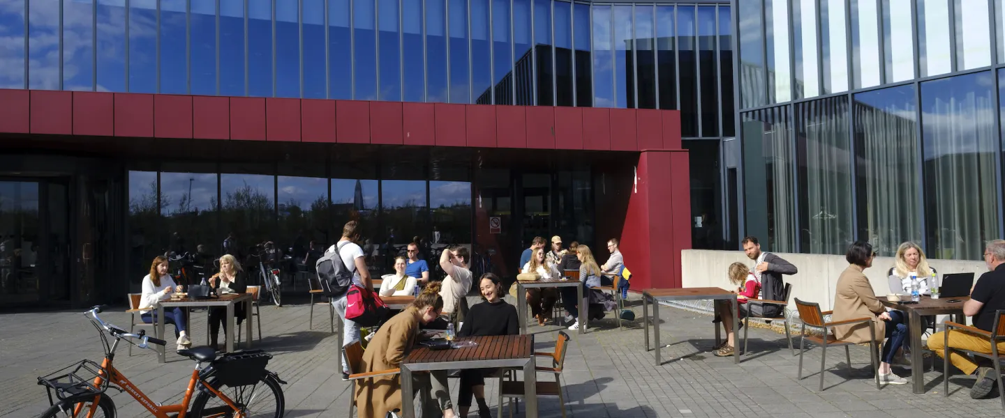 People sitting in the sun outside of University centre in the summertime