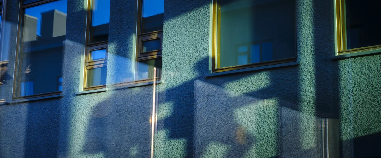 Shadows of people outside of Gamli Garður, University of Iceland