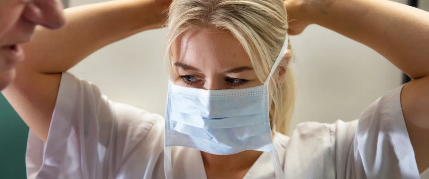 Nurse putting on a face mask
