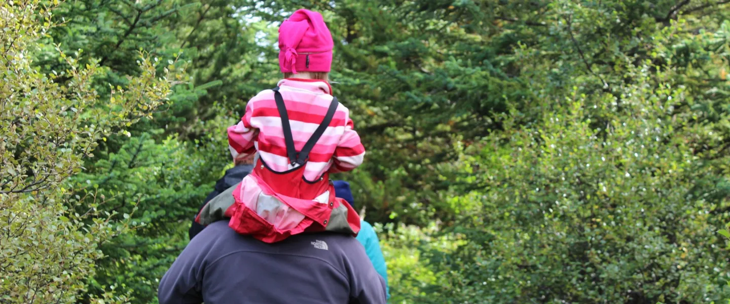 Young person sitting on man's shoulders