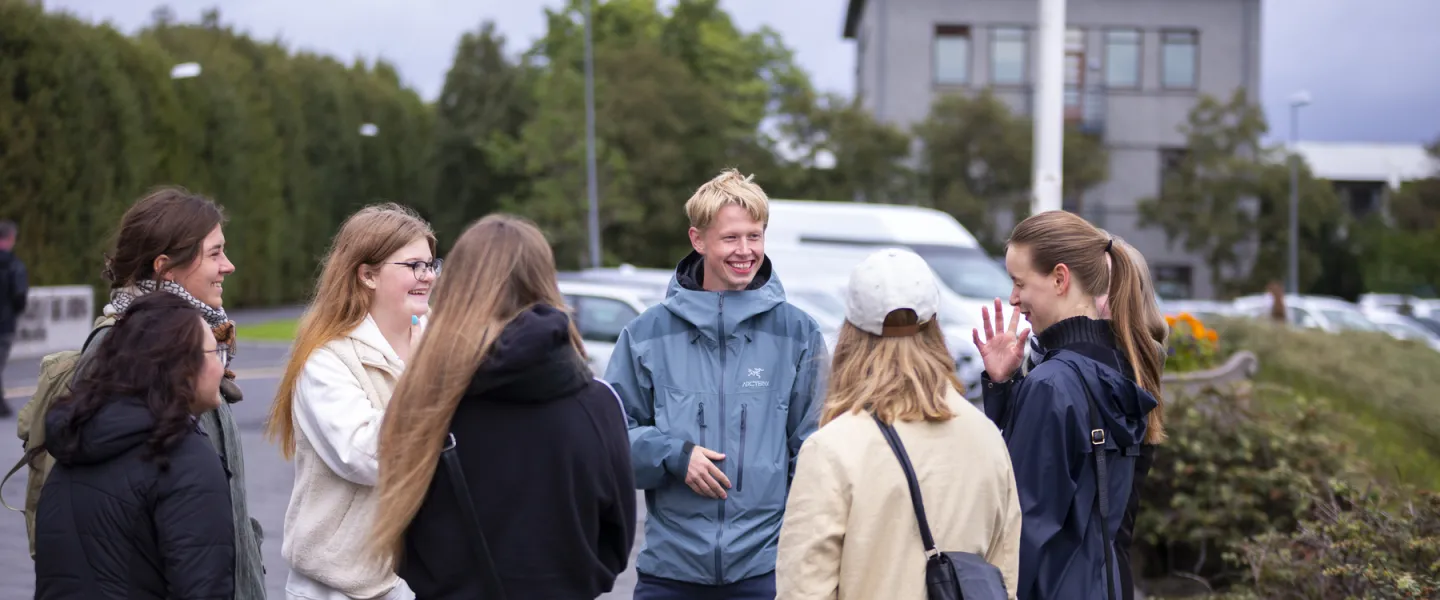 People standing outside University of Iceland Main building. Setberg in the Background