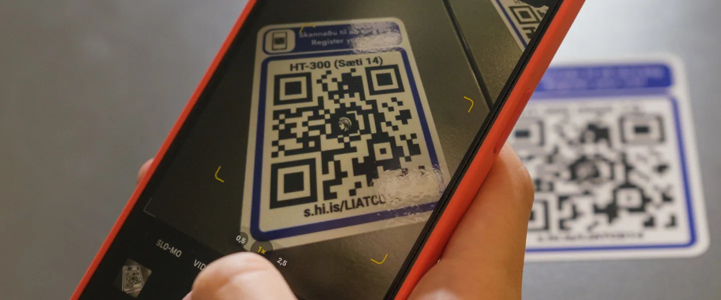 Hand holding a telephone, scanning a qr-code