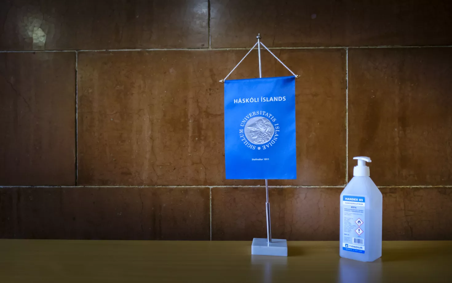 Covid, sanitizer, flag with University of Iceland logo