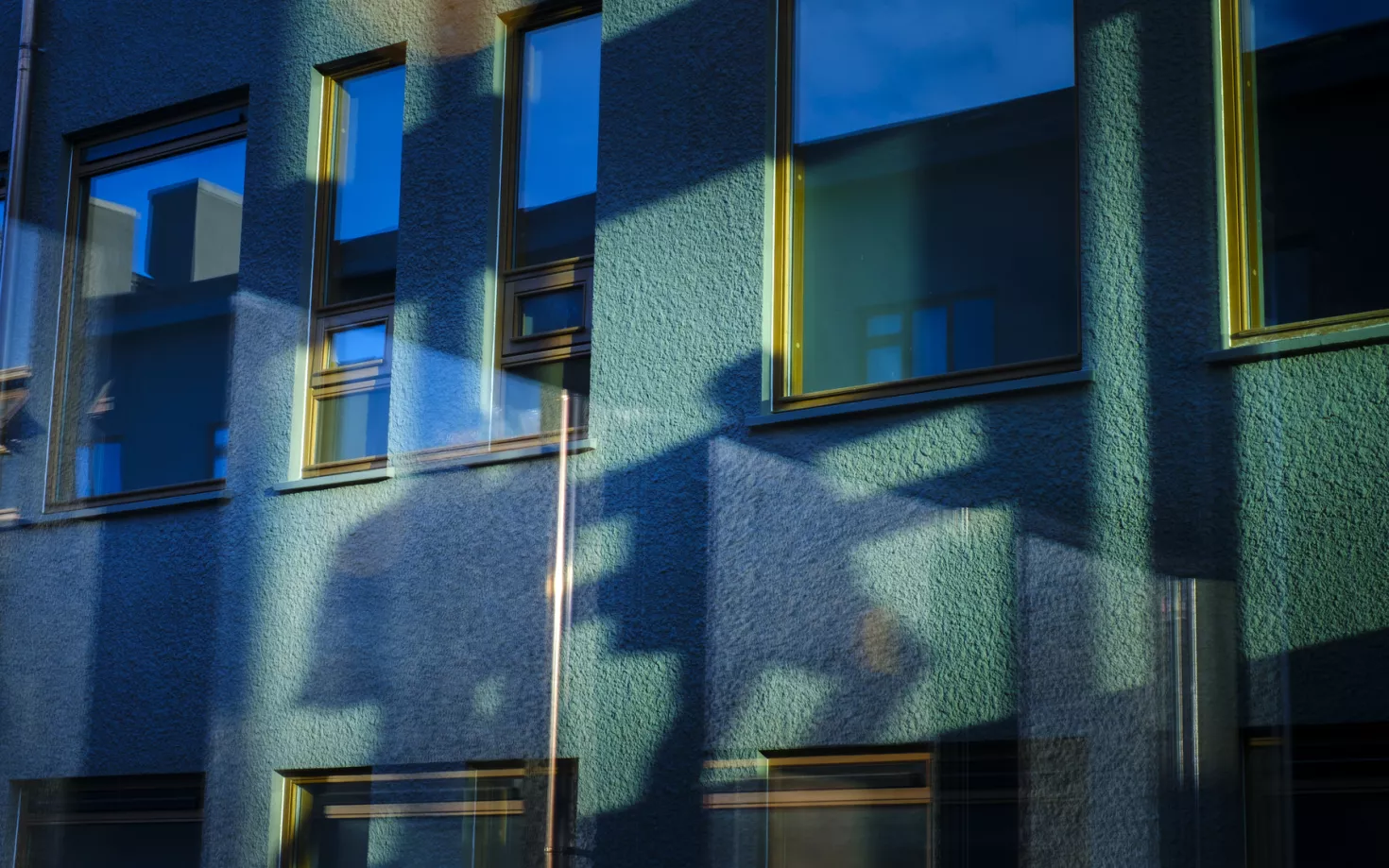 Shadows of people outside of Gamli Garður, University of Iceland