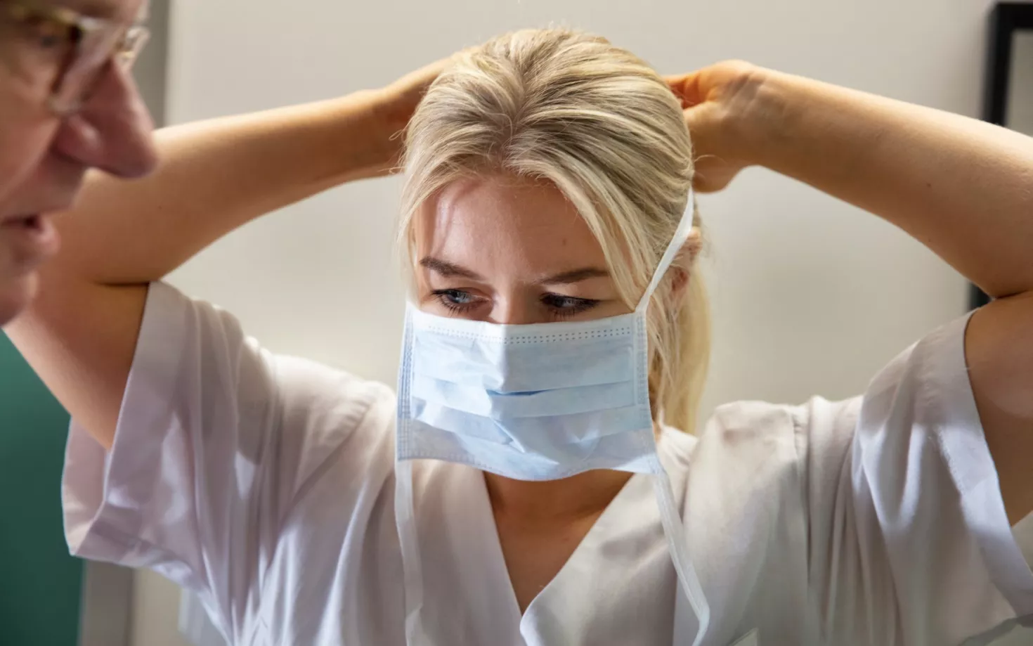 Nurse putting on a face mask
