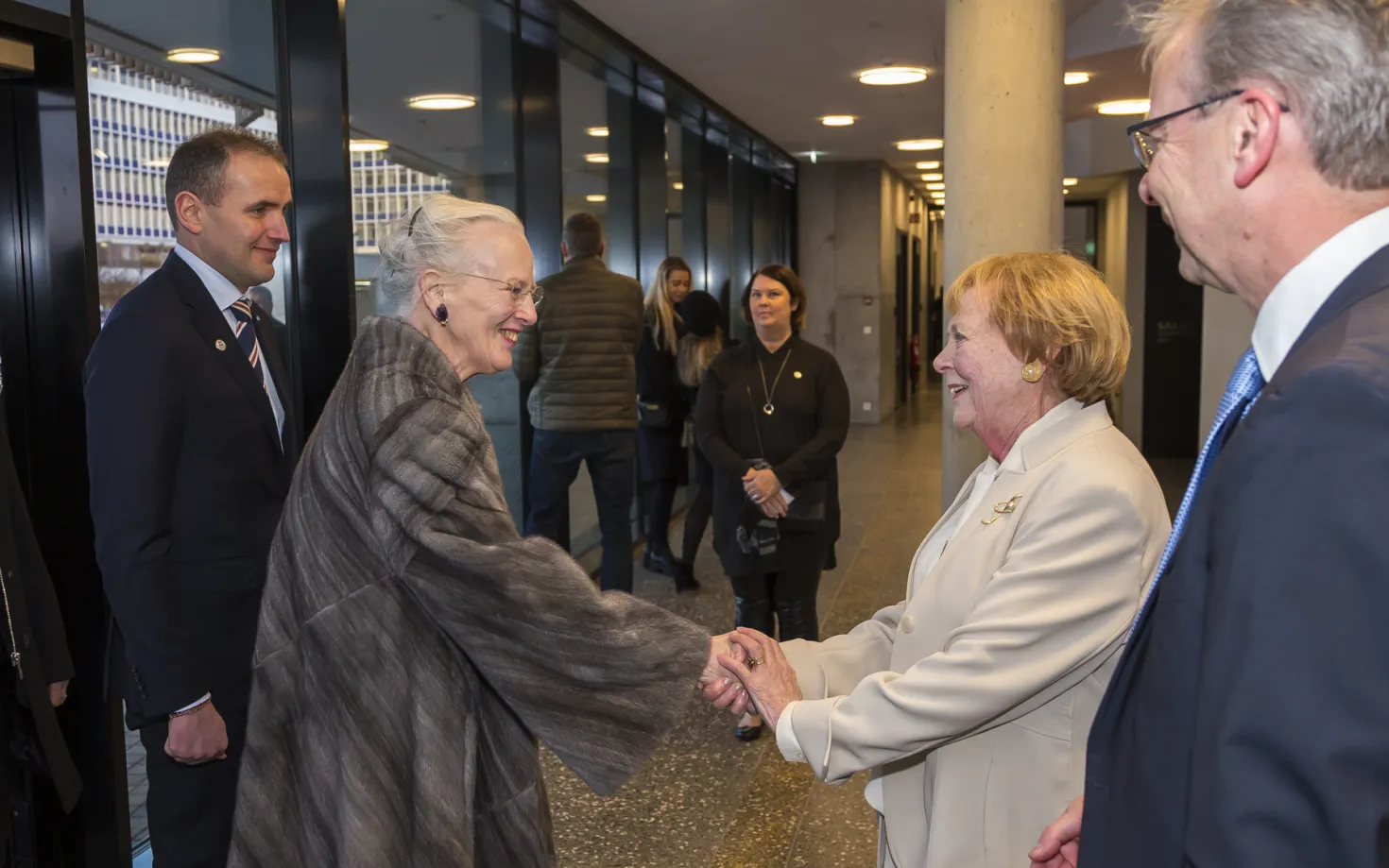 Vigdís Finnbogadóttir shaking hands with Queen Margrethe of Denmark. Guðni Th. Jóhannesson president of Iceland and Jón Atli Benediktsson rector of University of Iceland stand with them.
