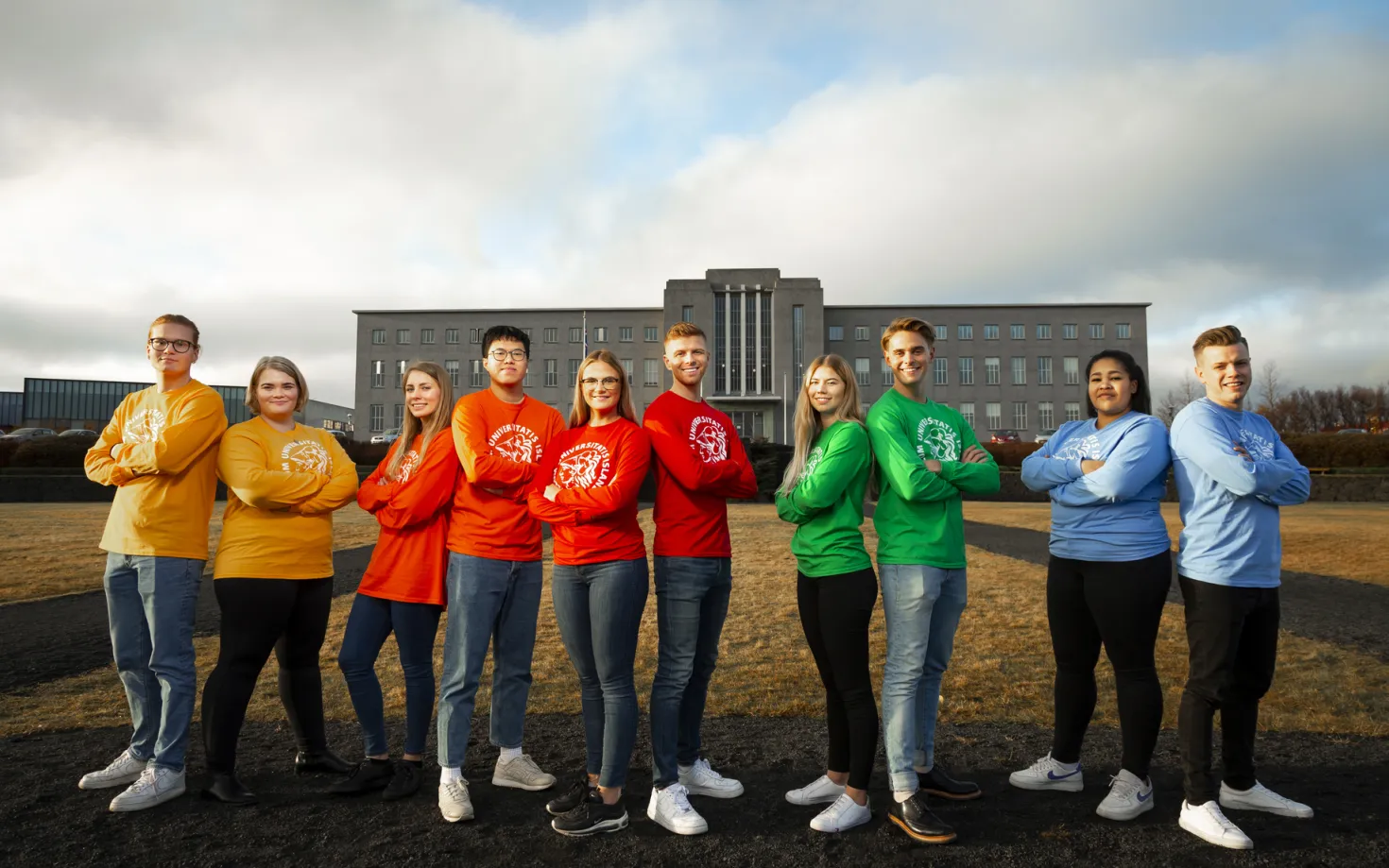 Students in colorful t-shirts, outside of University of Iceland Main building