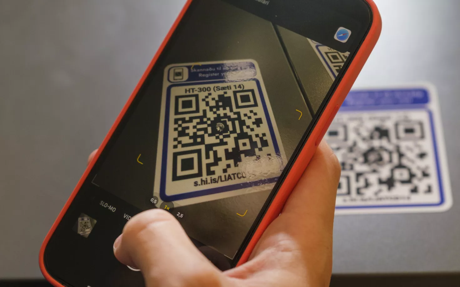 Hand holding a telephone, scanning a qr-code