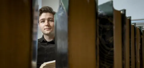 Student sitting behind books