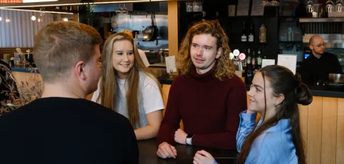 Four students talking to each other.