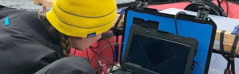 Research student monitoring sea bottom from a boat. 