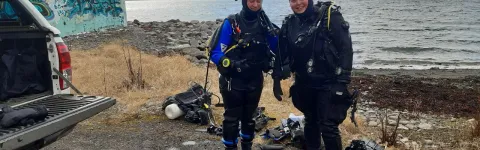 Two research divers in full gear on surface.