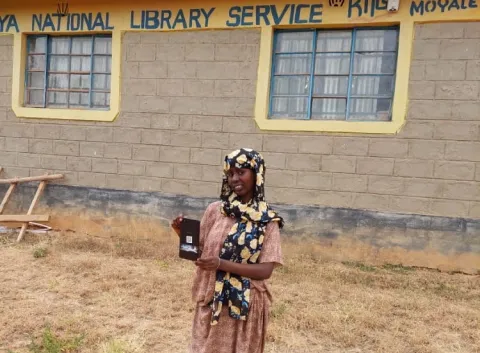 A young woman in Kenya with a tablet bought with SmileyCoins acquired by solving math problems.