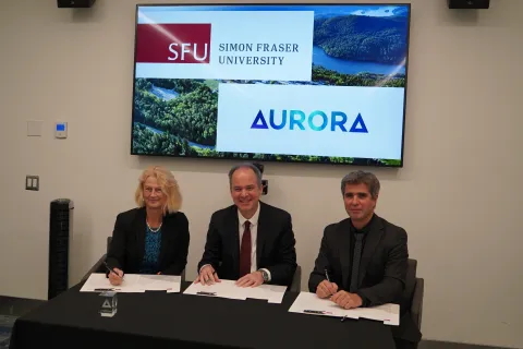 Ramon Puros, secretary general of the Aurora network signs a partnership agreement with representatives from Simon Fraser University.