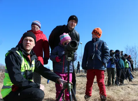 Children looking at birds using a spotting scope.