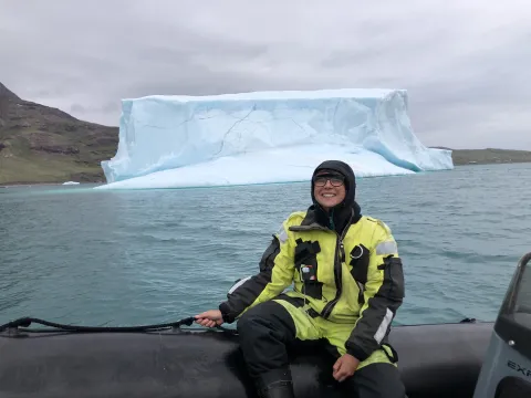 Alice on a boat with a glacier