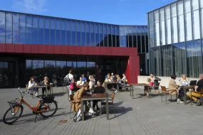 People sitting in the sun outside of University centre in the summertime