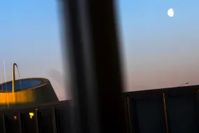 University centre, moon in the sky, lights reflecting from the window