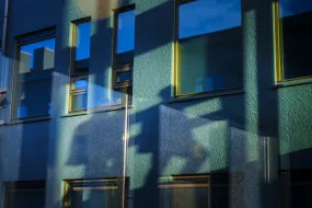 Shadows of people outside of Gamli Garður, University of Iceland