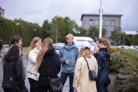 People standing outside University of Iceland Main building. Setberg in the Background