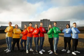 Students in colorful t-shirts, outside of University of Iceland Main building