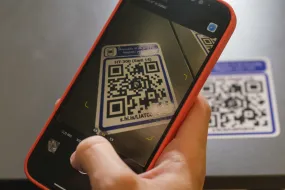 Hand holding a telephone, scanning a qr-code