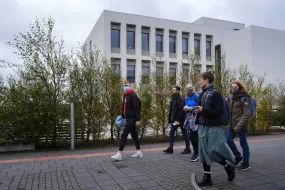 People with face masks walking outside of Lögberg