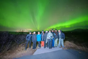 Aurora students standing outside under northern lights.